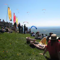 air de décollage du mont Myon avec plusieurs pilotes en l'air et du soleil