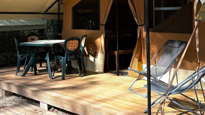 view terasse de la lodge masaai avec deux fauteuils de camping et table et chaises de jardin